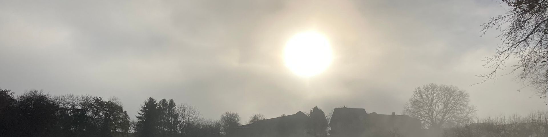 Weiler im Gegenlicht und Nebel im Jura