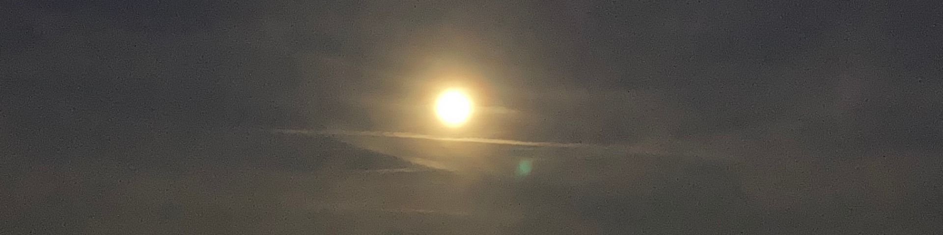 Vollmond über dem Jura im Nebel